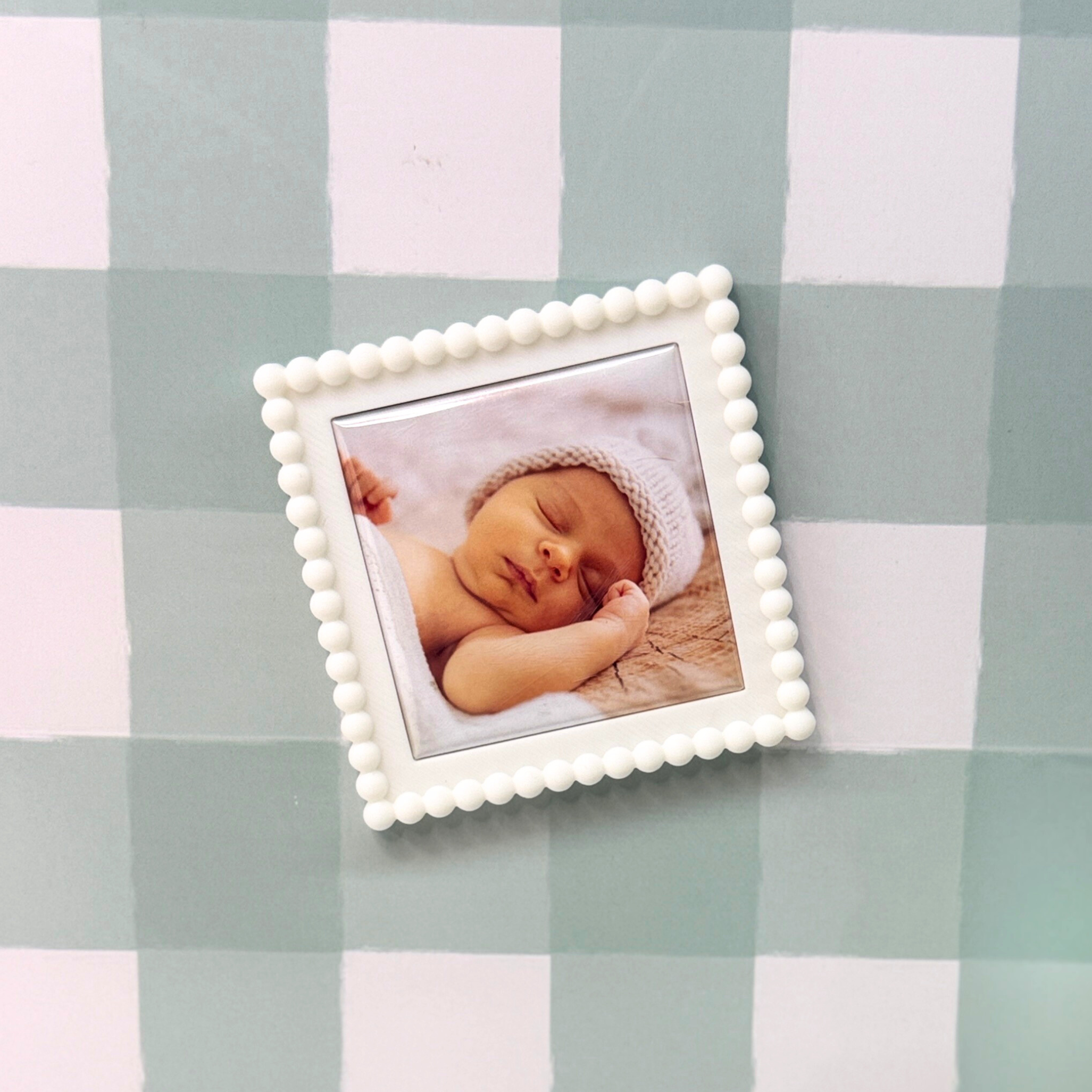 Small framed picture of a baby on a checkered fabric background