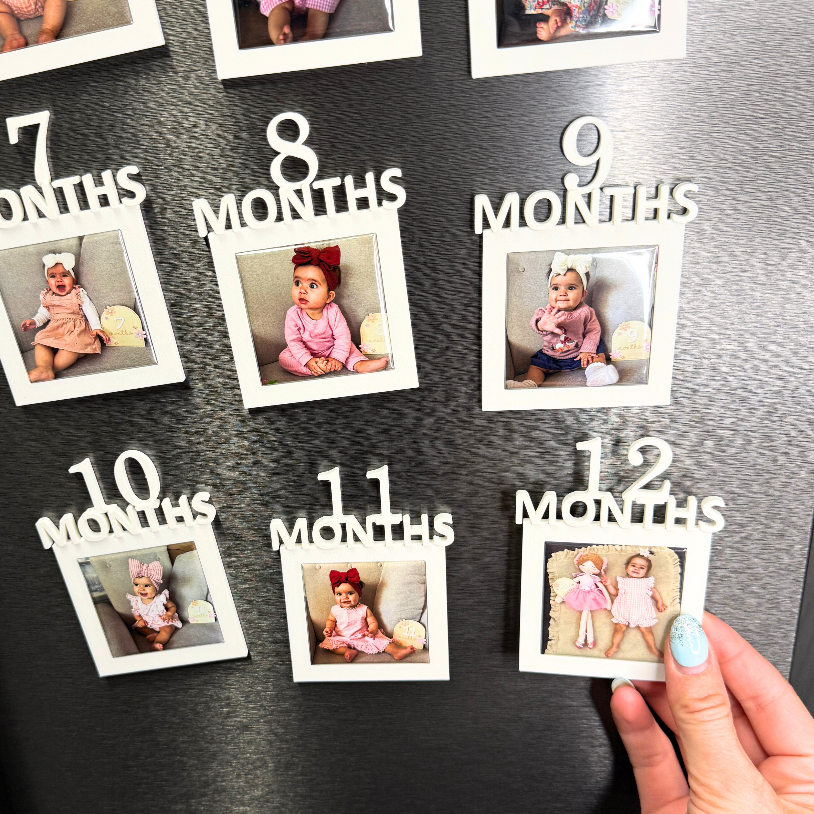 Fridge with baby milestone magnets and photos from 7 to 12 months.