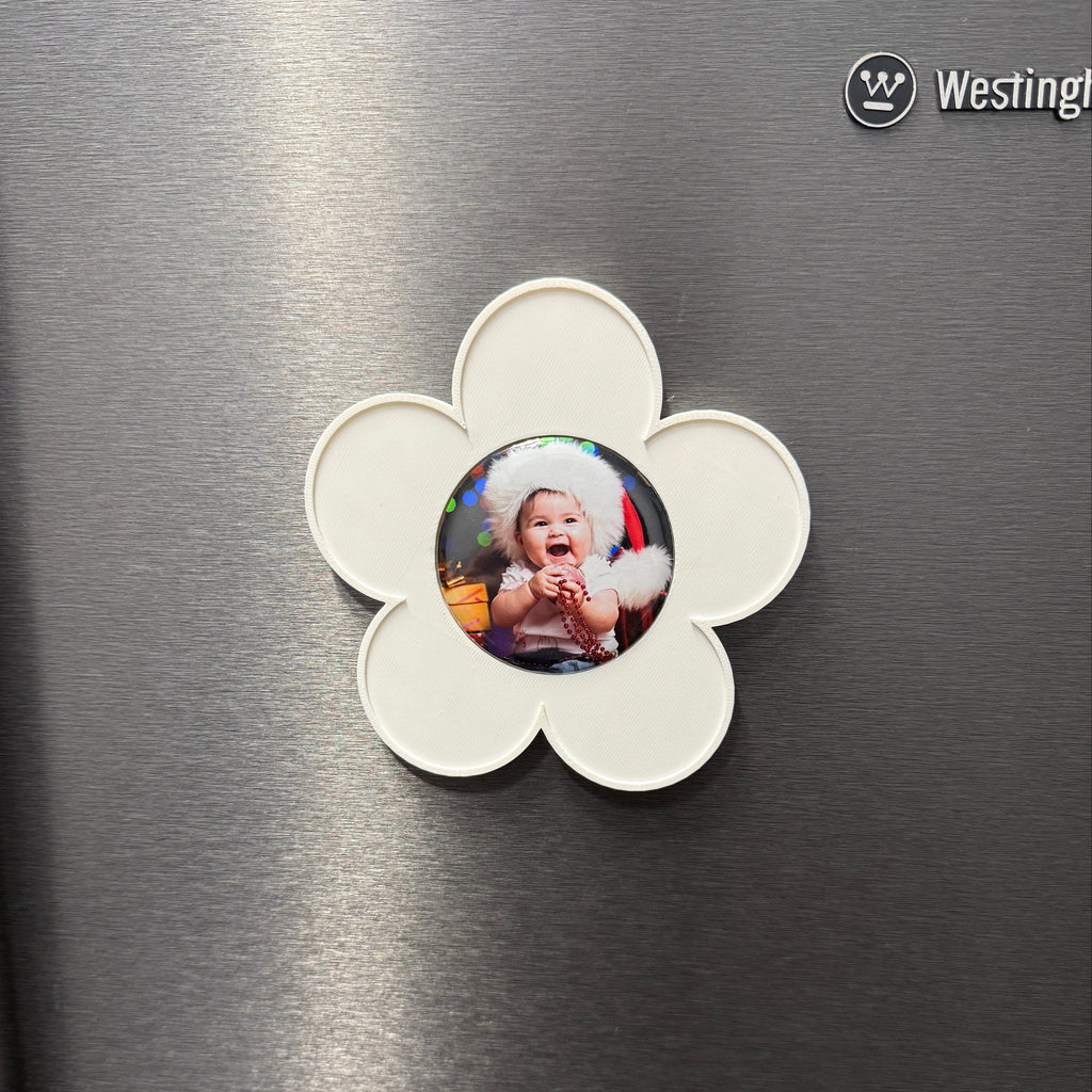 Flower-shaped photo holder with a picture of a baby on a metallic surface