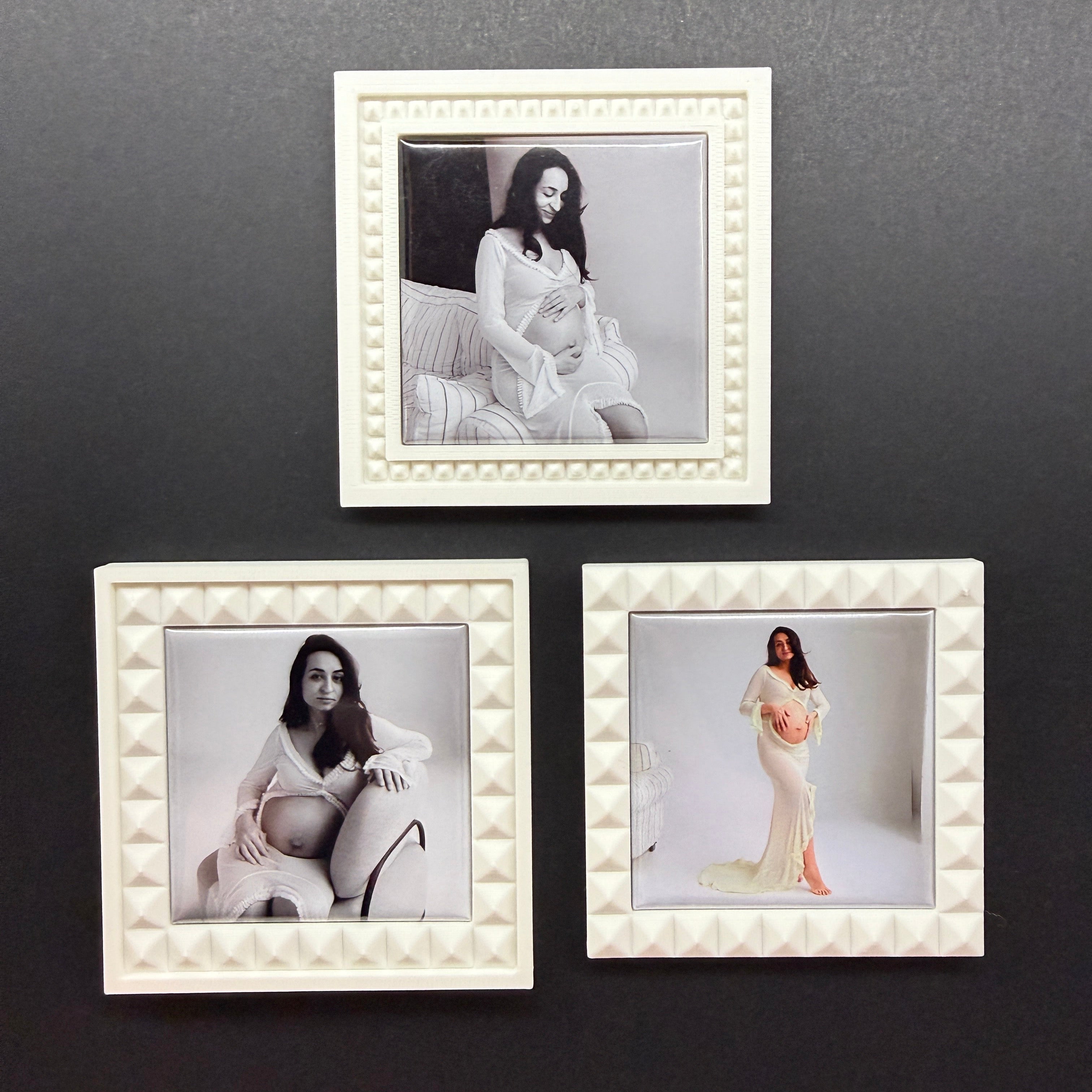 Three decorative photo frames on a dark wall with images of a woman.