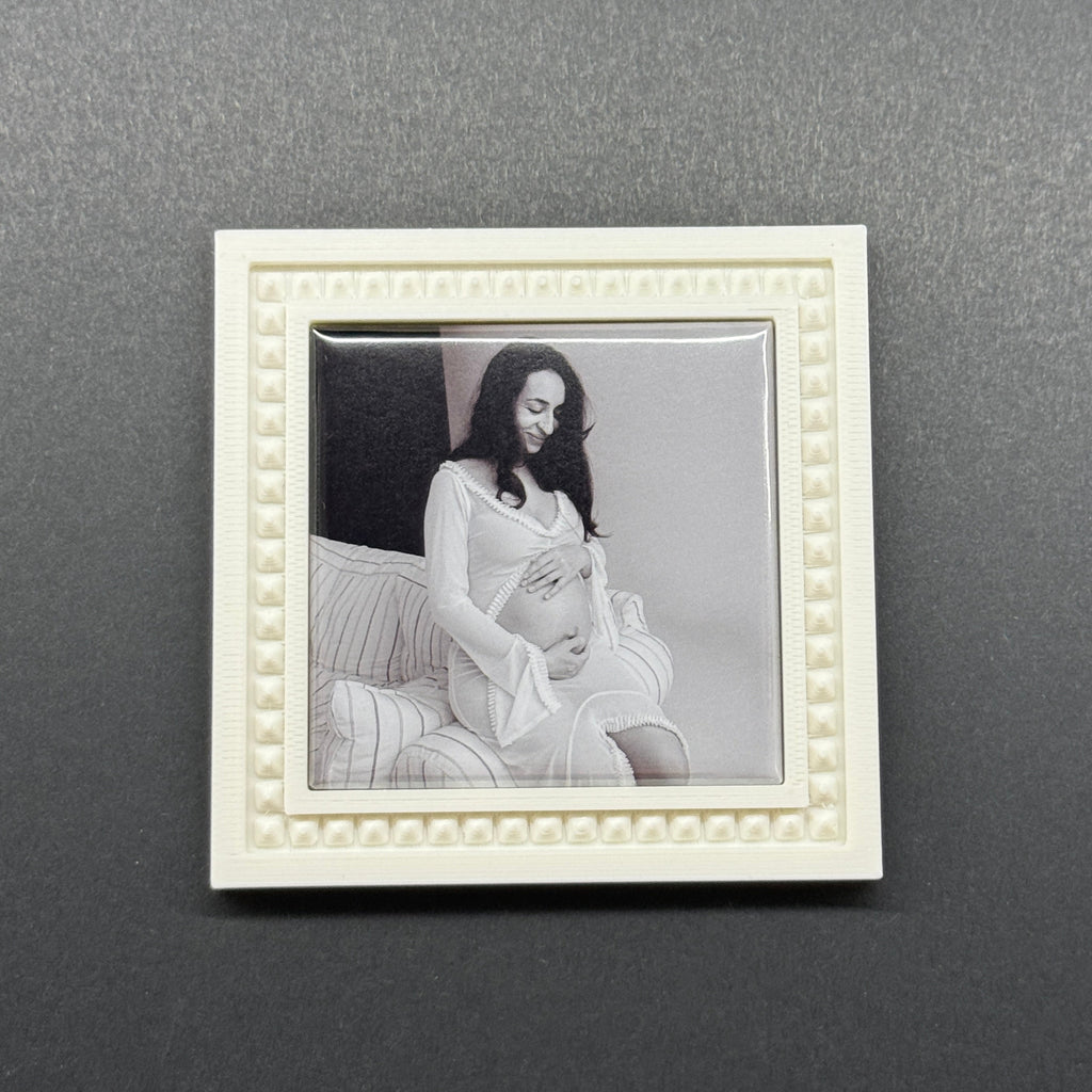 Framed black and white artwork of a woman and child on a gray wall