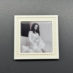 Framed black and white artwork of a woman and child on a gray wall