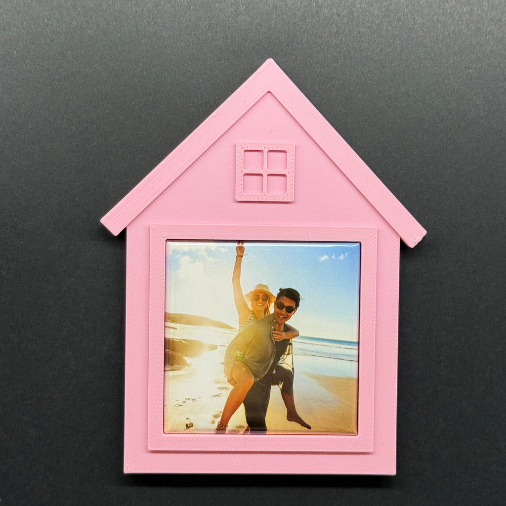Pink house-shaped photo frame on a black background