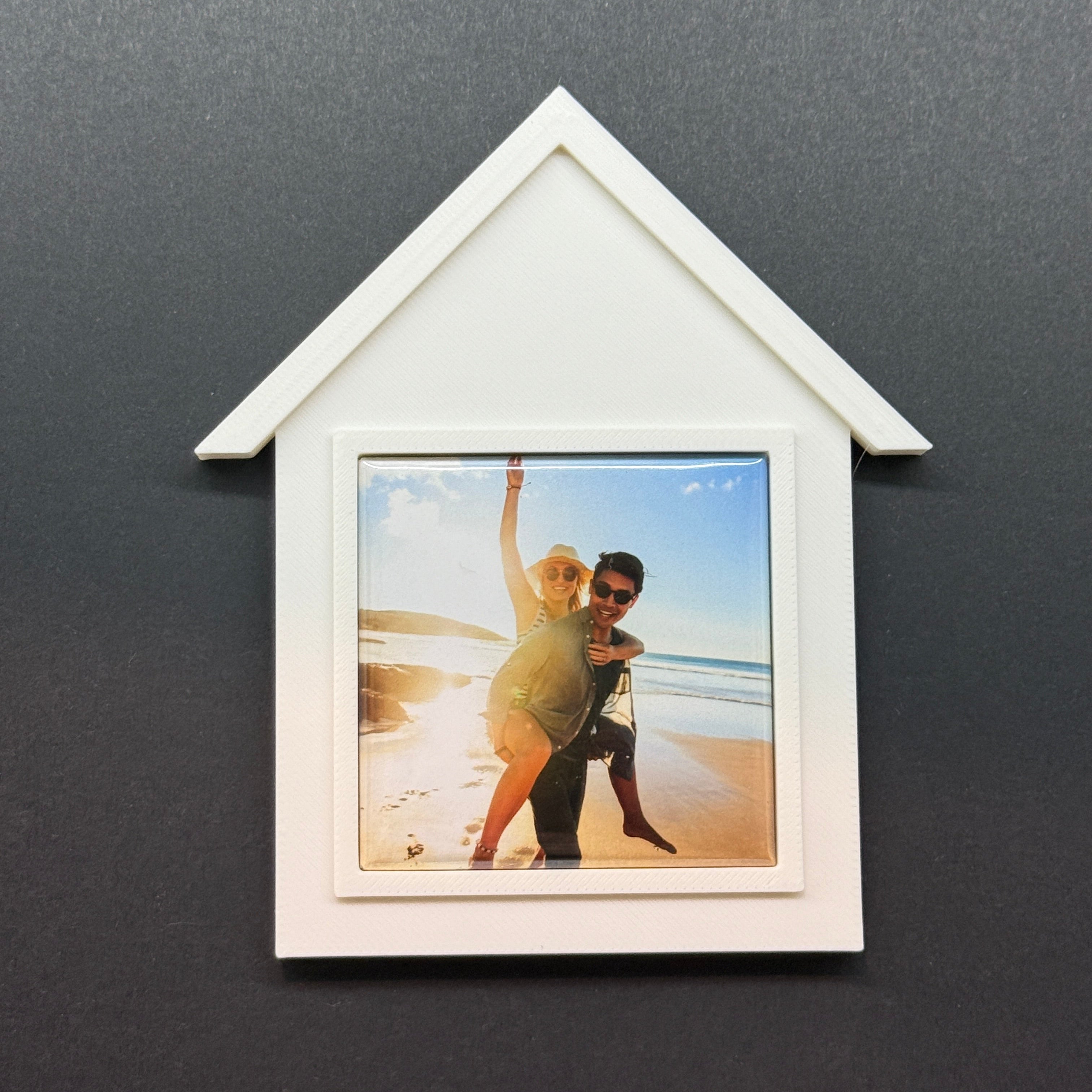 White arrow-shaped photo frame with a picture of two people on a gray background