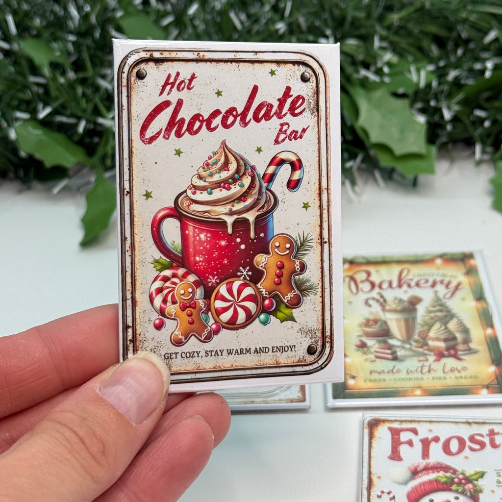 Hand holding a decorative hot chocolate bar packaging with festive design.