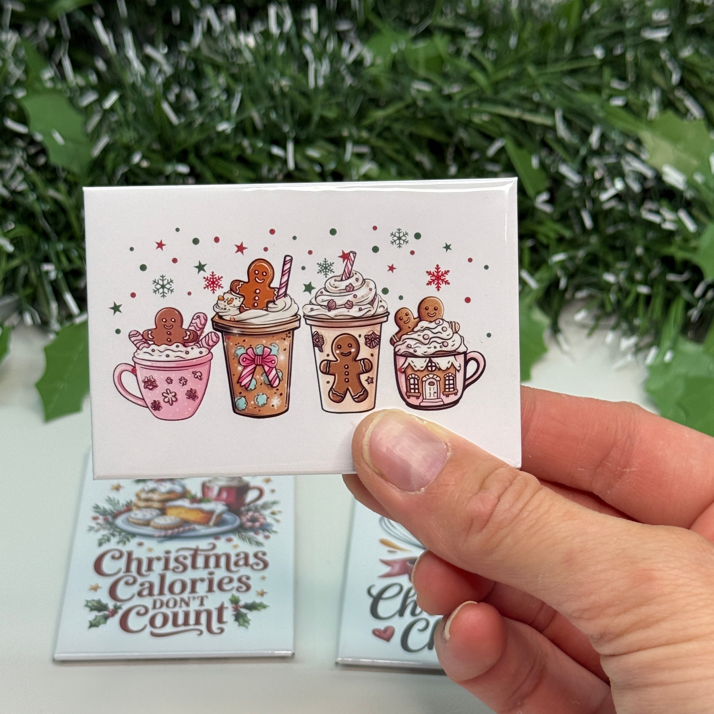 Hand holding a small card with Christmas-themed designs and text.