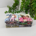 Stack of photo magnets on a white surface with green plants in the background