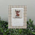 Christmas card with reindeer design and 'Merry Christmas' text on a checkered background.