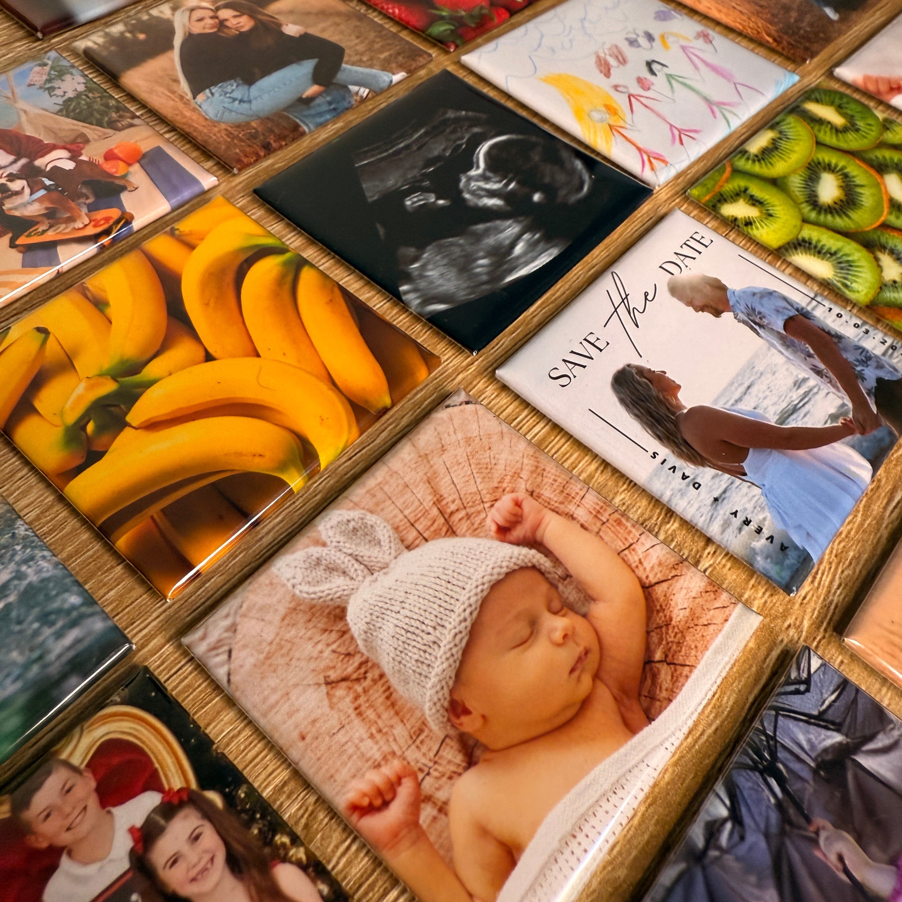 Australian handmade custom photo magnets displayed on wood, featuring baby photo, ultrasound, wedding save the date, kids’ drawings and vibrant fruit — a personalised gift idea for her, him, or any occasion.