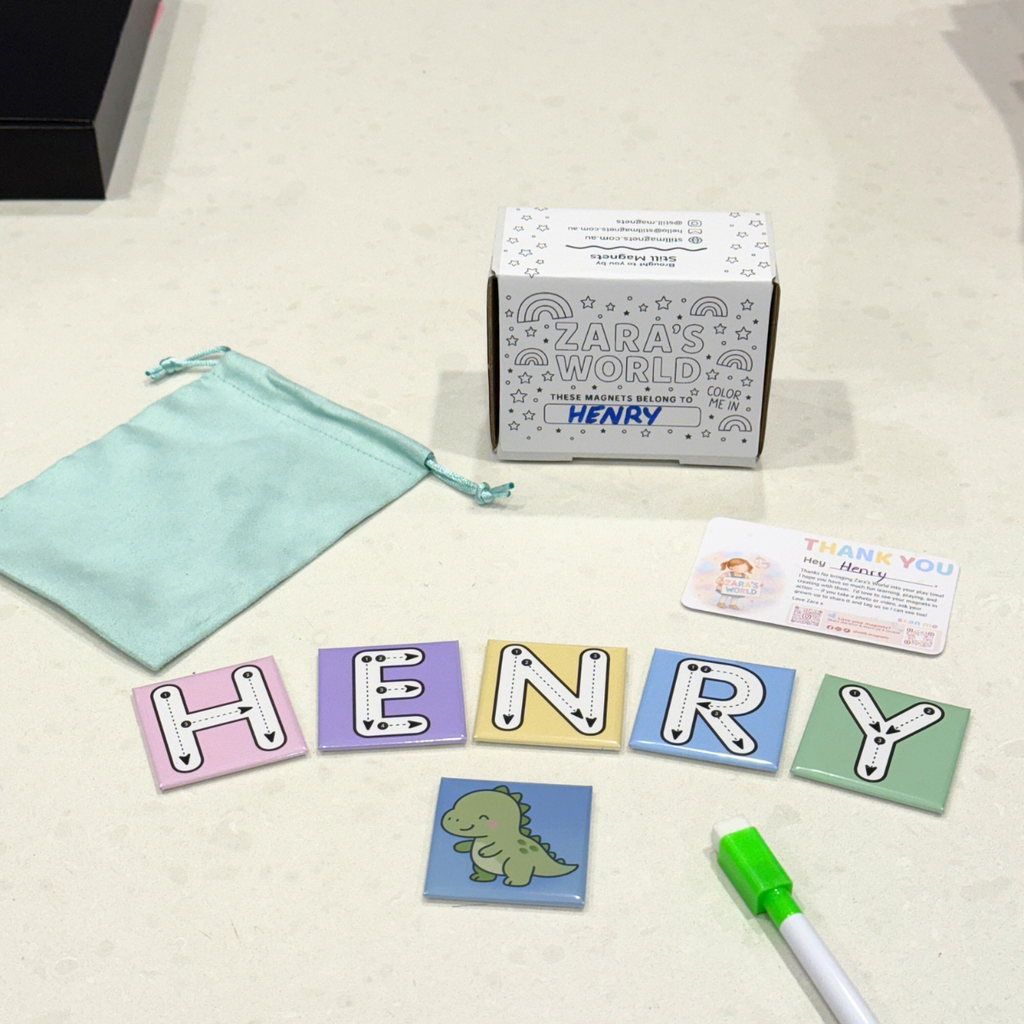 Children's letter tiles spelling 'HENRY', a small pouch, and a box labeled 'Zara's World' on a light surface.