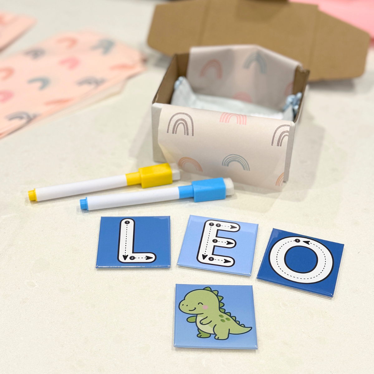 Educational children's items including letter cards and markers on a light surface.